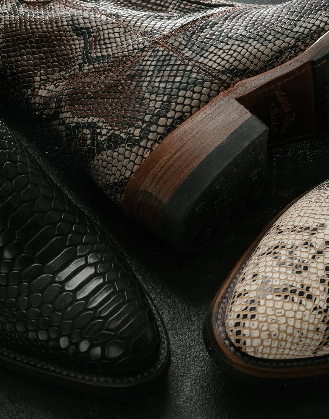 Closeup of Heartbreaker boots in black, white, and brown snake