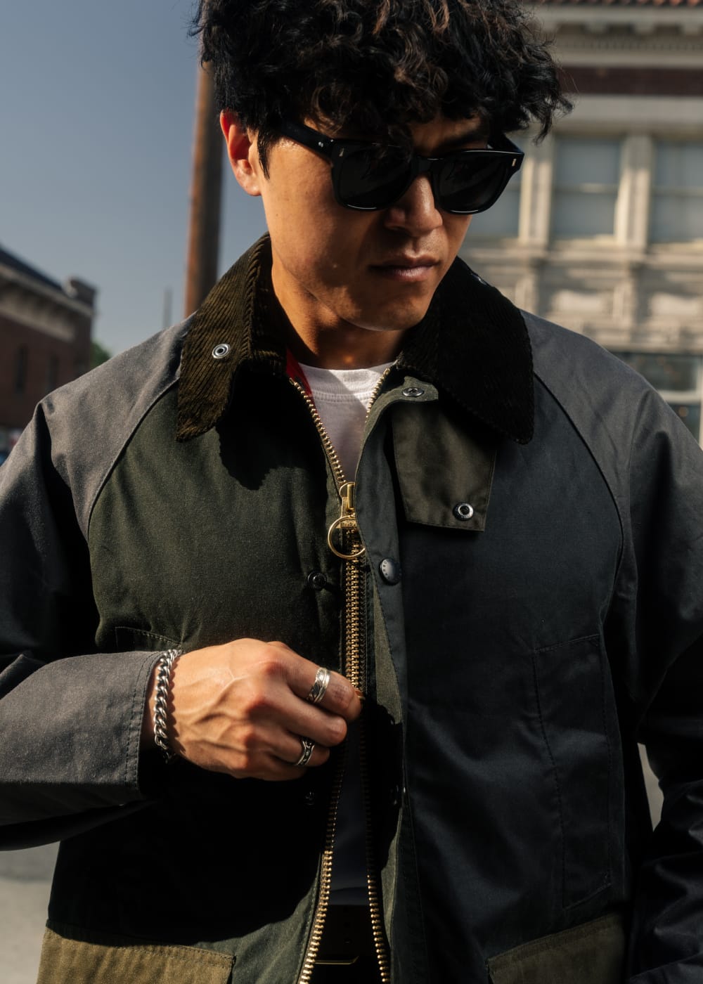 Man wearing a dark jacket with a fur-lined hood in an urban setting