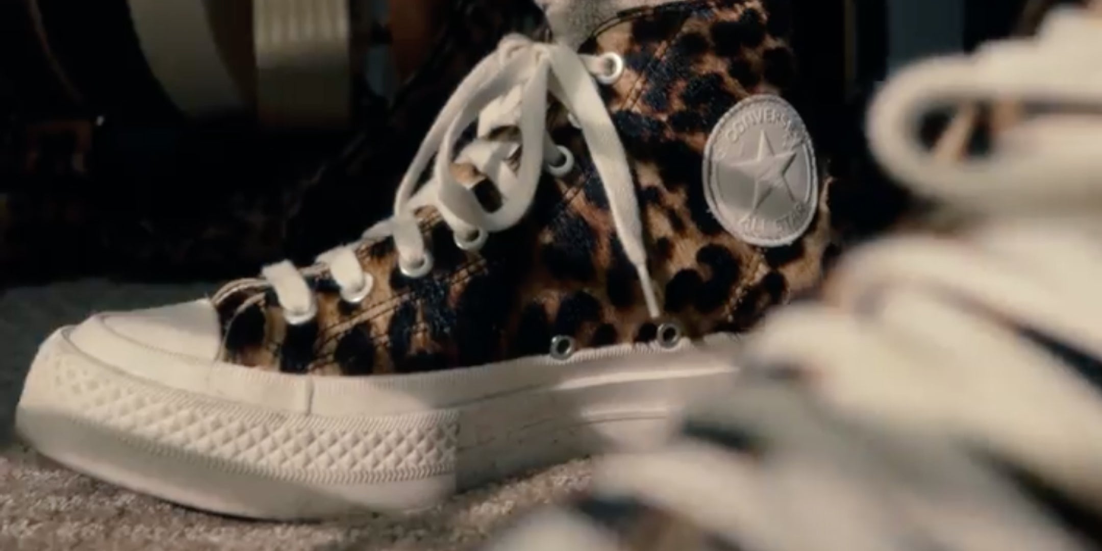 Leopard print high-top sneakers with white laces and sole, featuring a star logo.