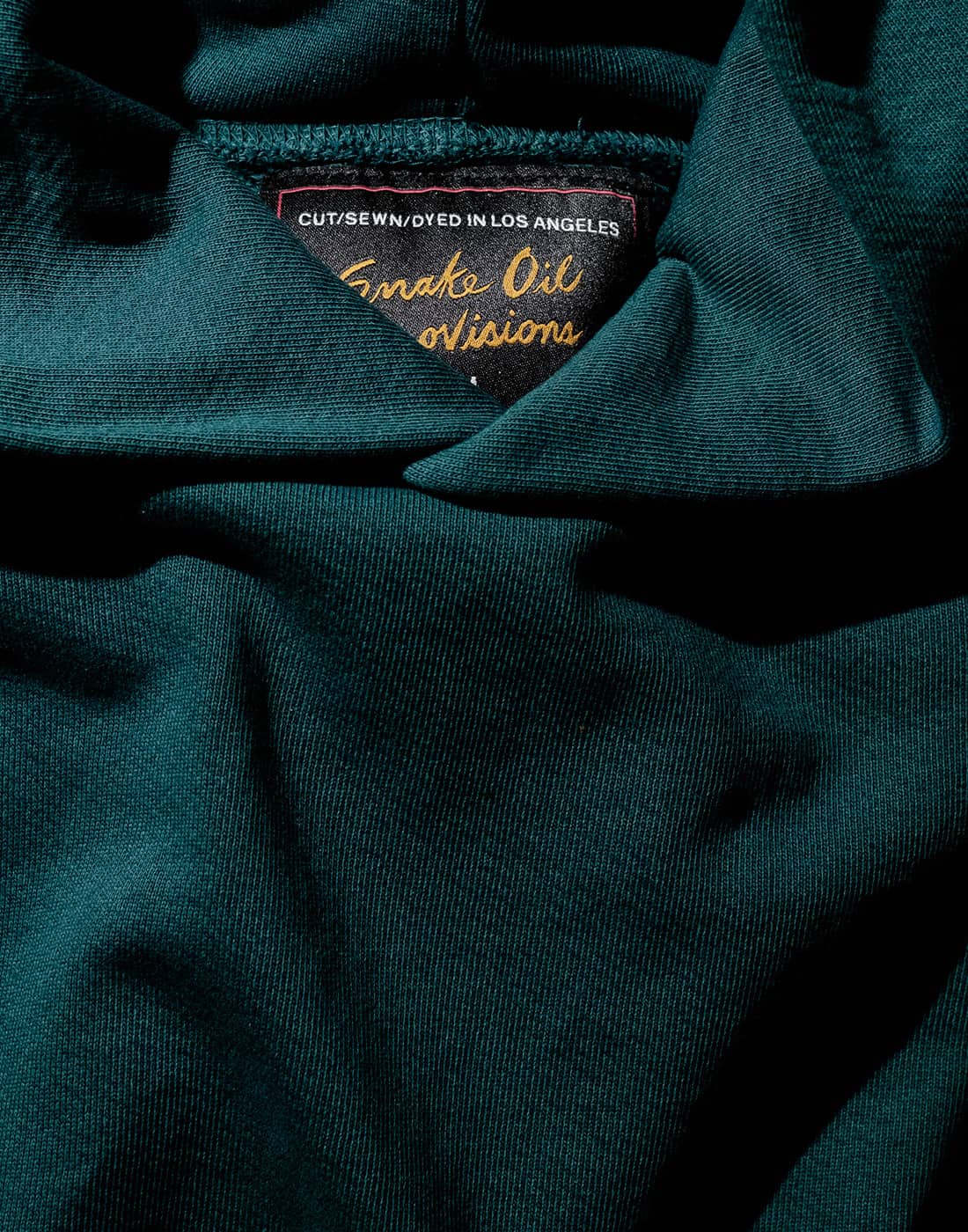 Closeup of an SOP French terry loopback hoodie in green