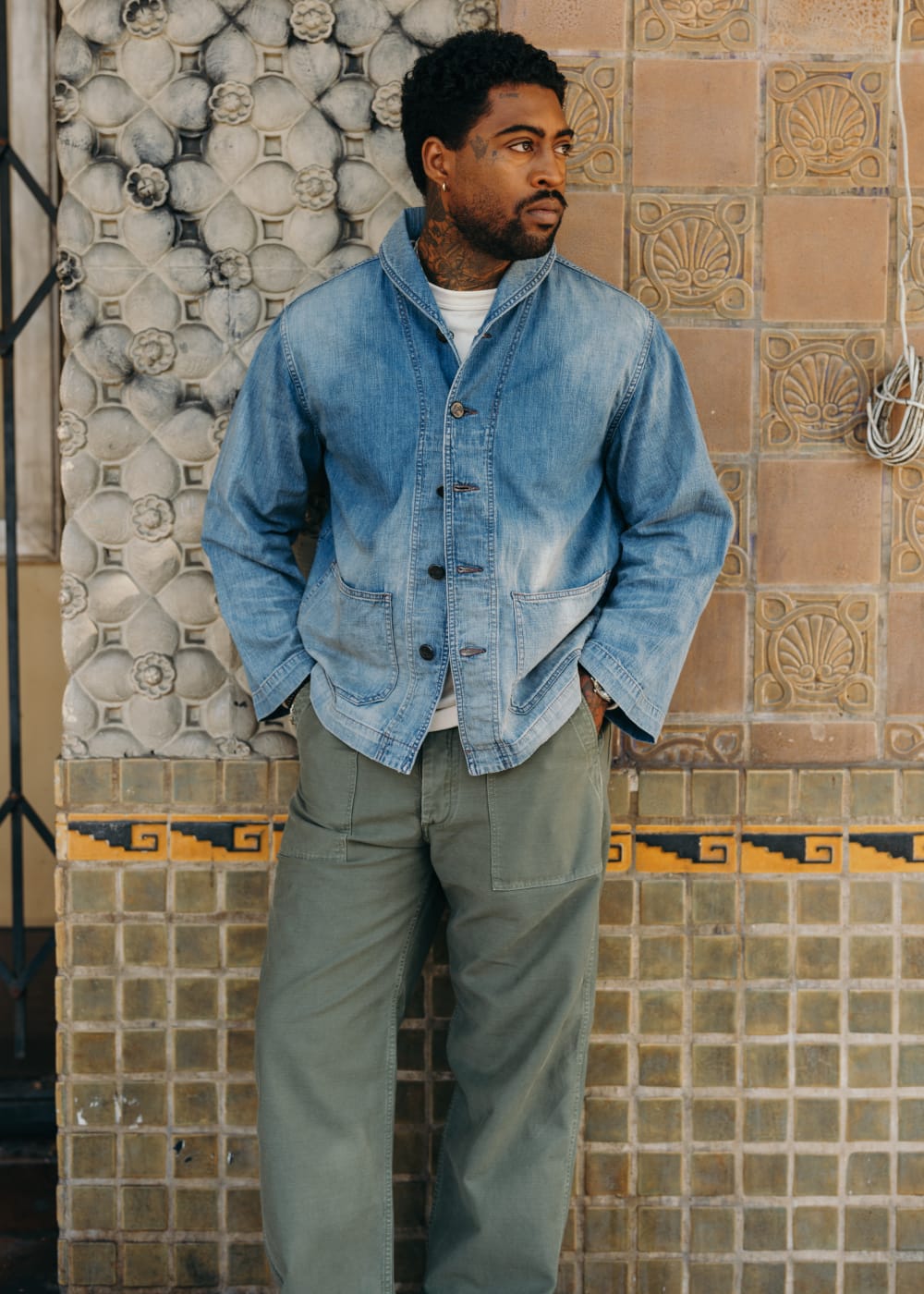Man wearing a denim jacket styled with olive work pants