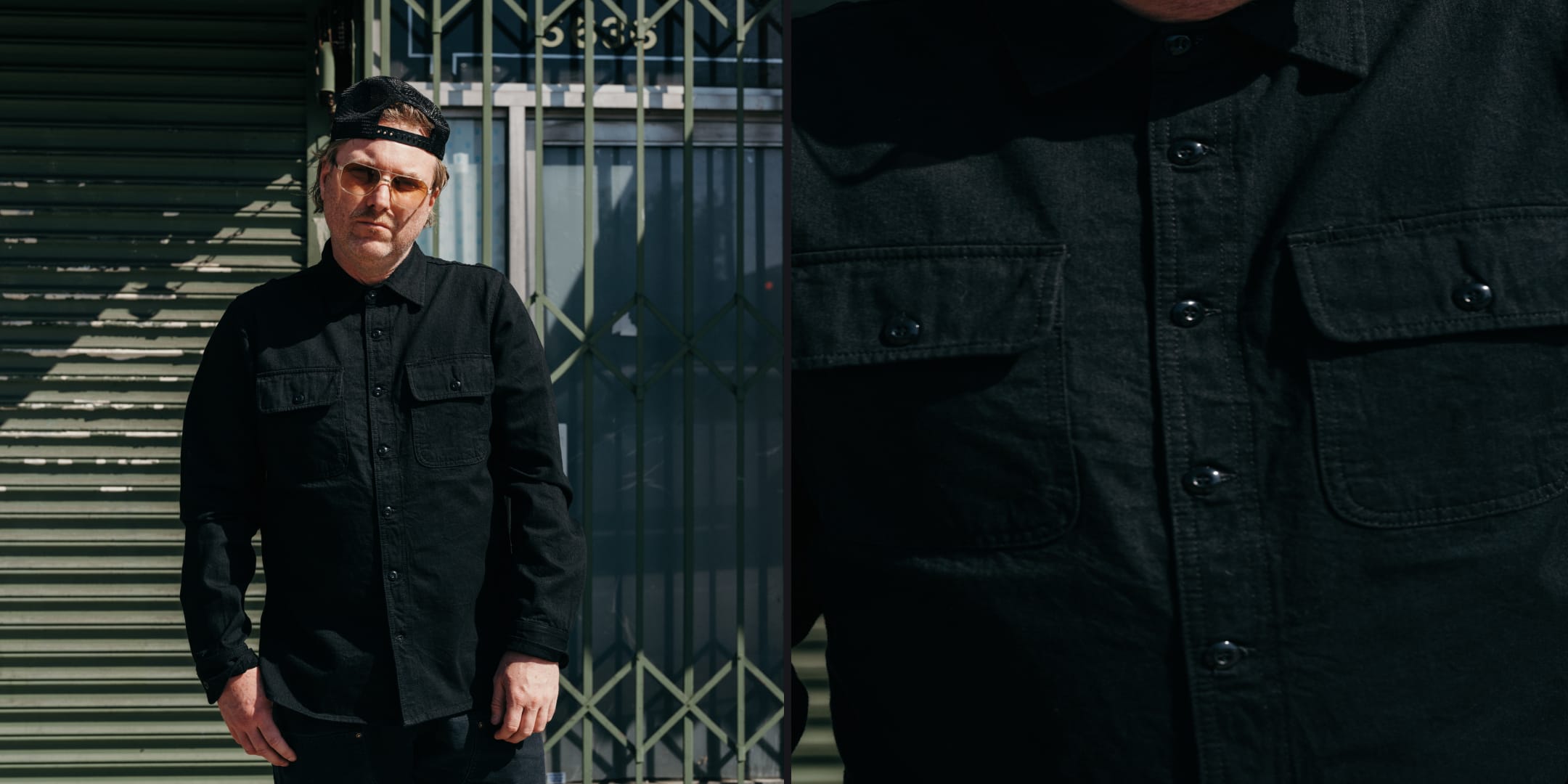 Person wearing a black jacket and cap standing in front of a metal gate.