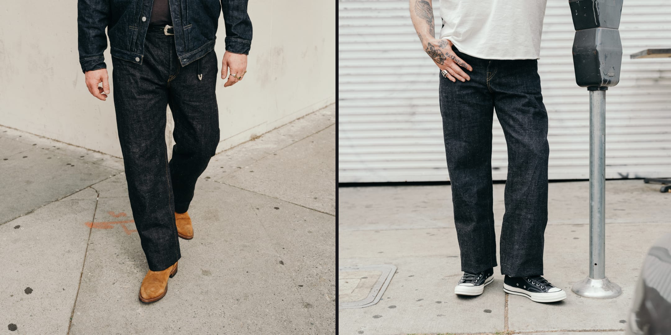 Two people wearing dark jeans standing on a sidewalk with a building in the background.