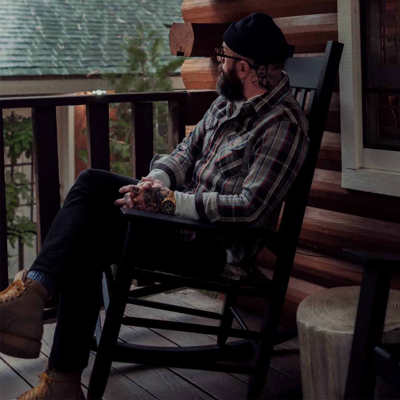SOP co-owner Ben Neuhaus sitting in a chair on a cabin porch